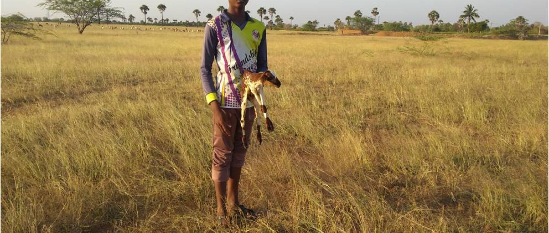 A young Konar boy with a newborn goat kid. Photo by Vikram Aditya.